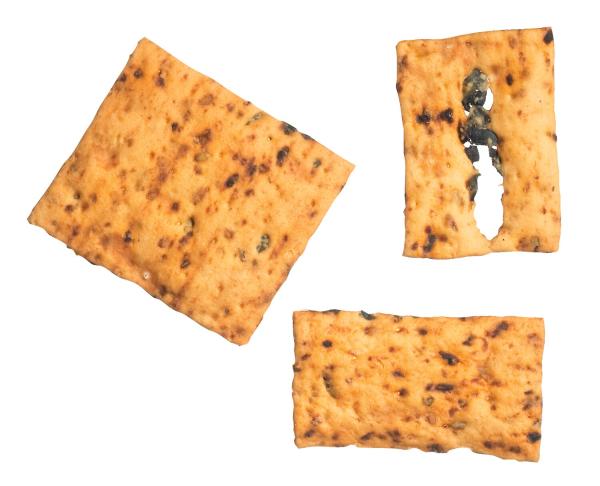 Knusprige Salzgebäck-Quadrate mit getrockneten Tomaten und schwarzen Oliven – goldbraun gebacken, mediterraner Snack